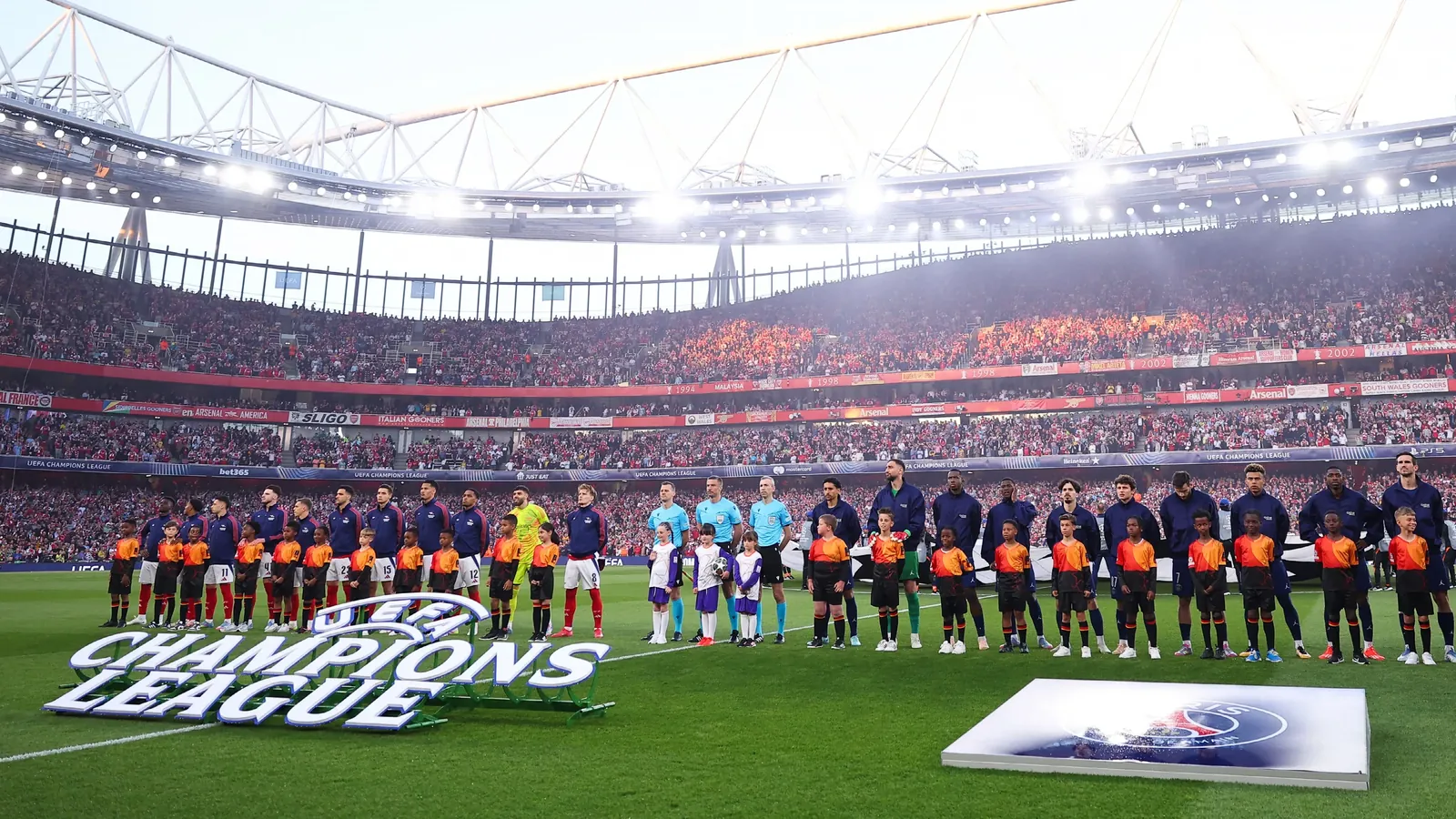 Spelers van Arsenal en Paris Saint-Germain (PSG) staan klaar voor de Champions League-hymne voorafgaand aan hun wedstrijd van vorig jaar