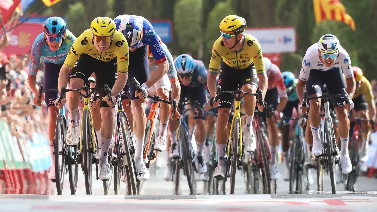 Lead-out Christophe Laporte kijkt hoe Matthew Brennan naar zijn tweede ritzege in de Vuelta sprint.